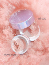 Two skincare containers, one labeled 'full-size' and the other 'travel-size', on a pink textured background.