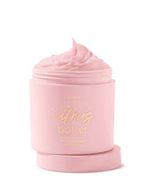 Pink jar of 'citrus butter' body scrub with visible brand name on a white background
